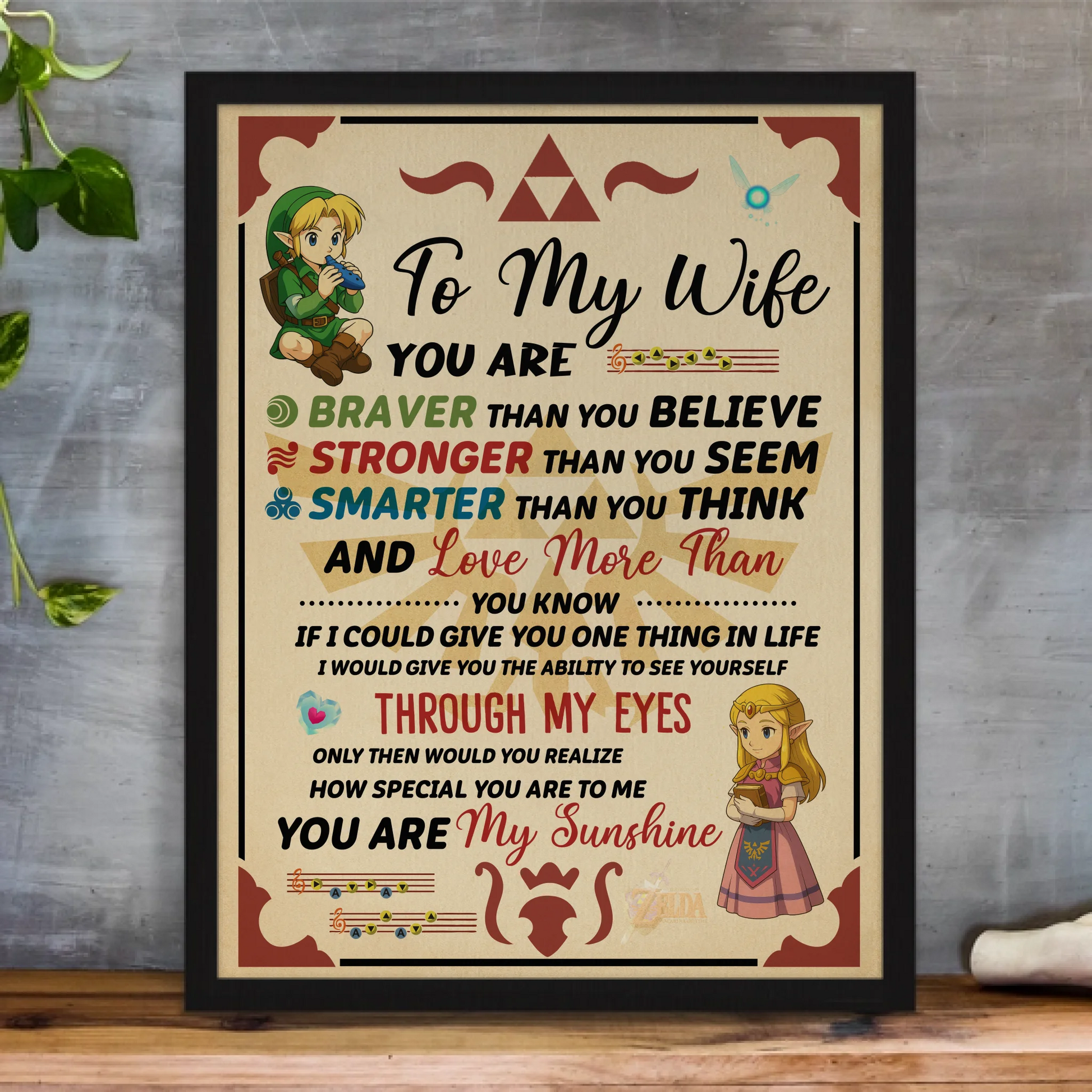 framed-art-print-standing-on-a-wooden-desk-against-a-concrete-wall-near-a-hand-decoration-a10403